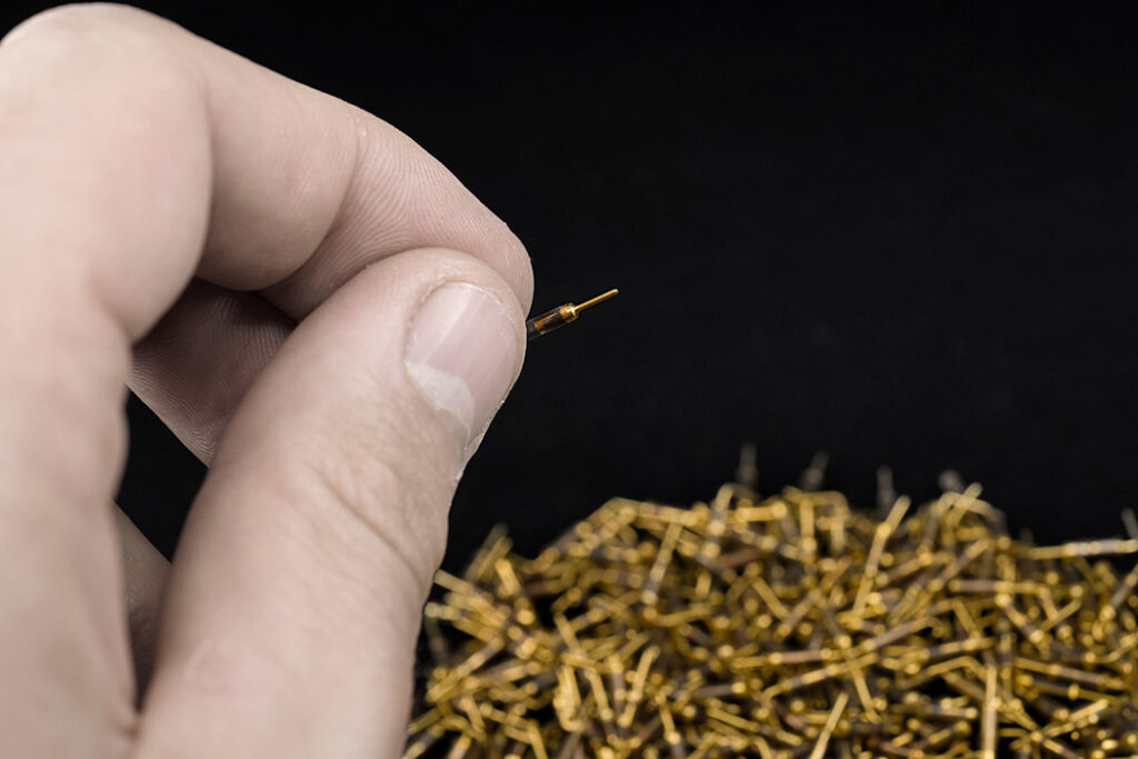 High-precision plated pins for electronic connectors, showcasing the uniform finish and exact tolerances maintained through Precious Plate’s automated process control systems.